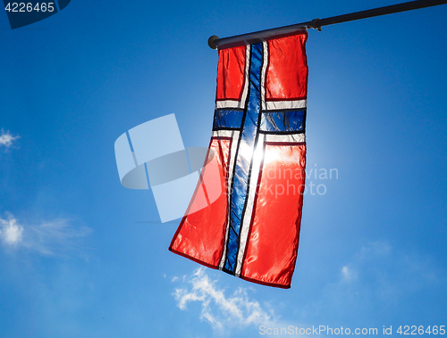 Image of Norwegian flag up close, towards the sun on beautiful blue sky