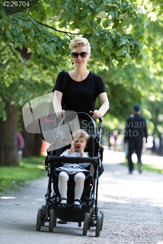 Image of mother pushed her baby daughter in a stroller