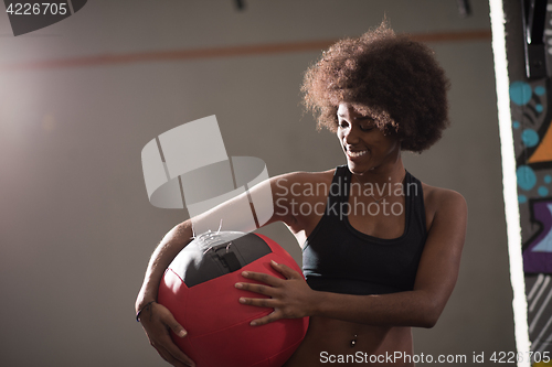 Image of black woman carrying crossfit ball