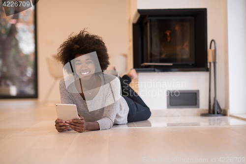 Image of black women using tablet computer on the floor