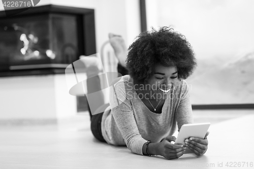 Image of black women used tablet computer on the floor