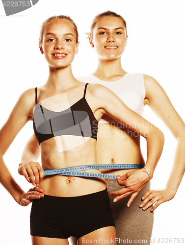 Image of two sport girls measuring themselves isolated on white