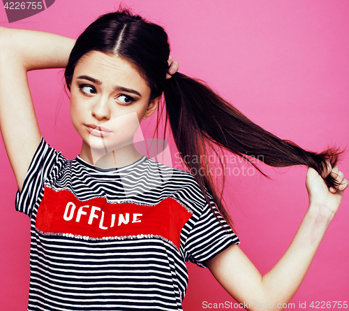 Image of young pretty teenage woman emotional posing on pink background, fashion lifestyle people concept 