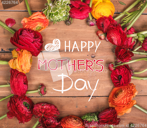 Image of Ranunkulyus bouquet of red flowers on a wooden background