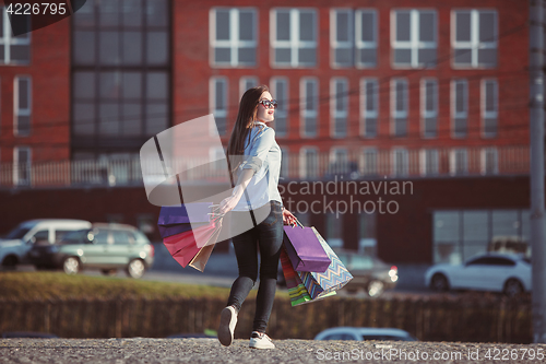 Image of The girl walking with shopping on city streets