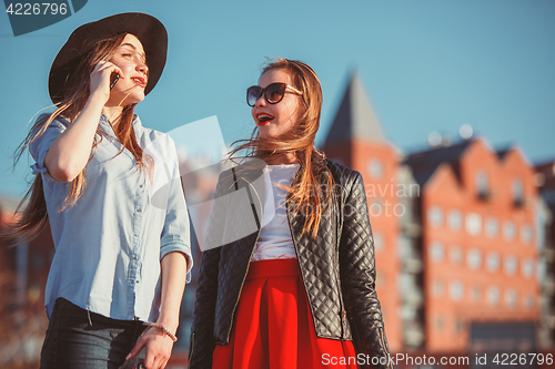 Image of Two girls walking with shopping on city streets