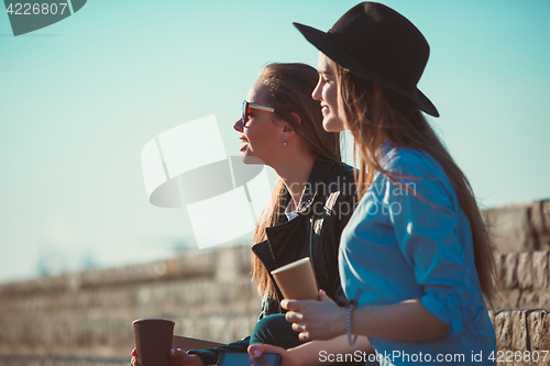 Image of Two girls walking with shopping on city streets