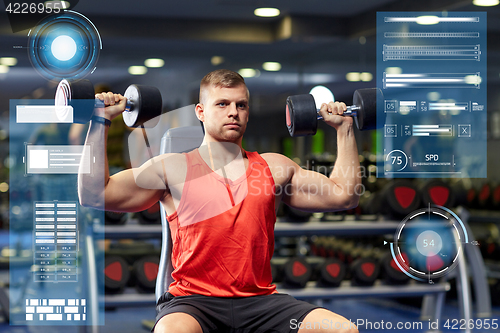 Image of young man with dumbbells flexing muscles in gym