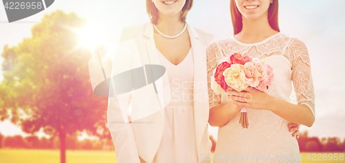 Image of close up of happy lesbian couple with flowers