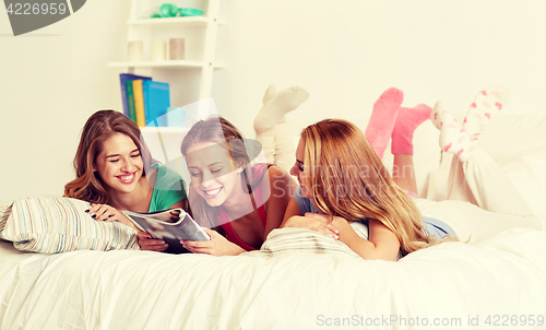 Image of friends or teen girls reading magazine at home