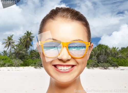Image of happy smiling teenage girl in shades over beach