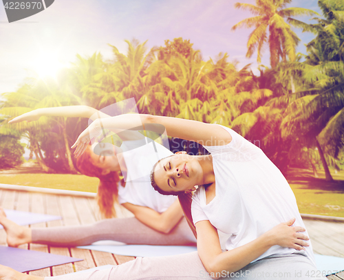 Image of women making yoga exercises outdoors