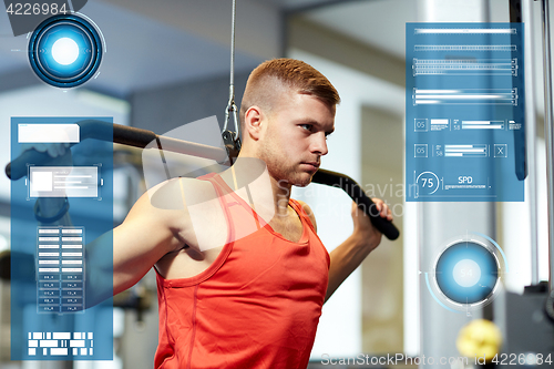 Image of man flexing muscles on cable machine gym