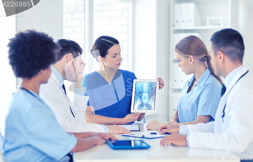 Image of group of doctors with x-ray on tablet pc at clinic