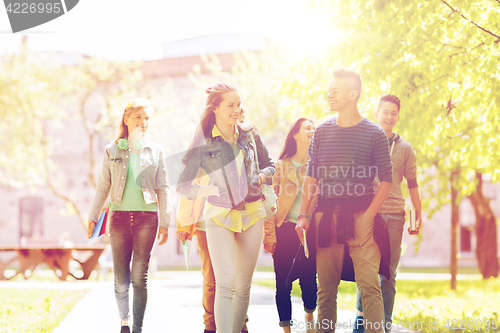 Image of group of happy teenage students walking outdoors