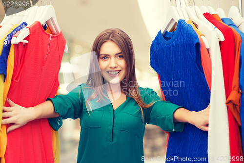 Image of happy woman choosing clothes at home wardrobe