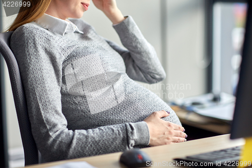 Image of pregnant businesswoman sitting at office