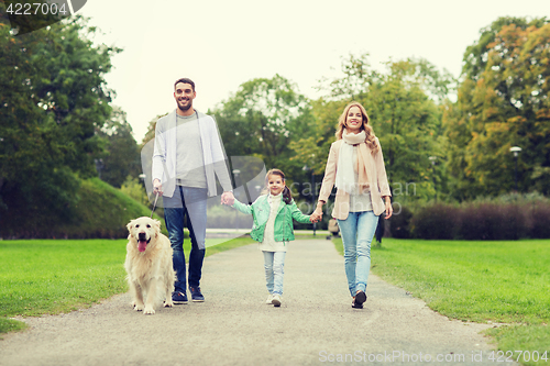 Image of happy family with labrador retriever dog in park