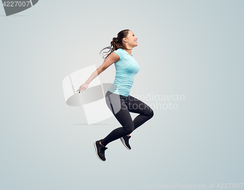 Image of happy smiling sporty young woman jumping in air