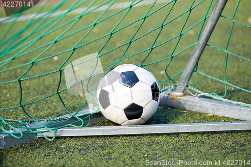 Image of soccer ball at goal net on football field