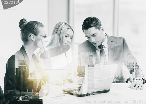 Image of business team with laptop having meeting at office