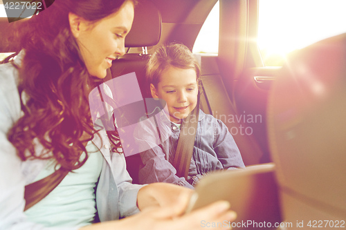 Image of happy family with tablet pc driving in car