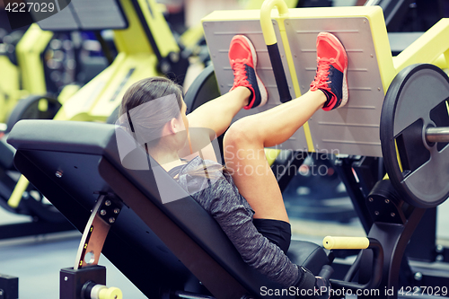 Image of woman flexing muscles on leg press machine in gym