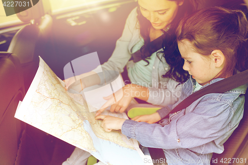 Image of happy family with travel map driving in car