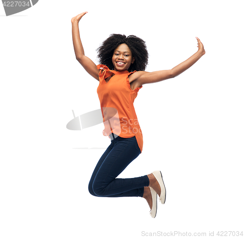 Image of happy african american woman jumping over white
