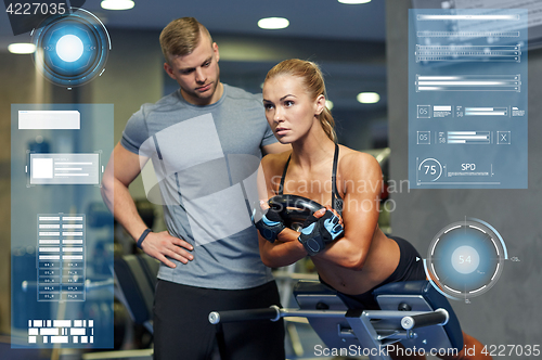 Image of woman with personal trainer flexing muscles in gym