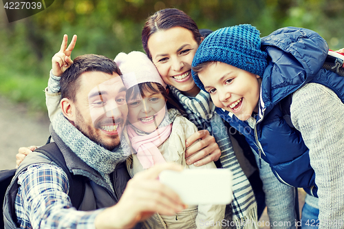 Image of family taking selfie with smartphone in woods