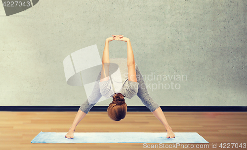 Image of woman making yoga in wide-legged forward bend pose