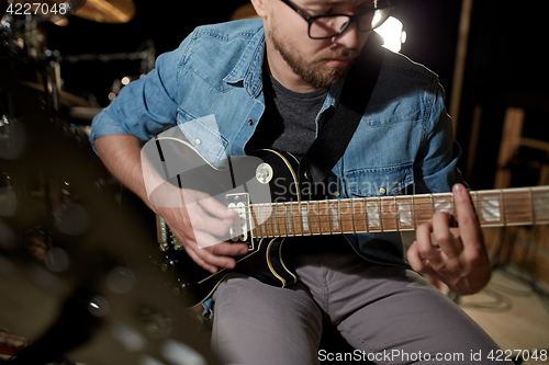 Image of man playing guitar at studio rehearsal