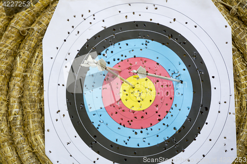 Image of Archery Target With Arrows On a straw background