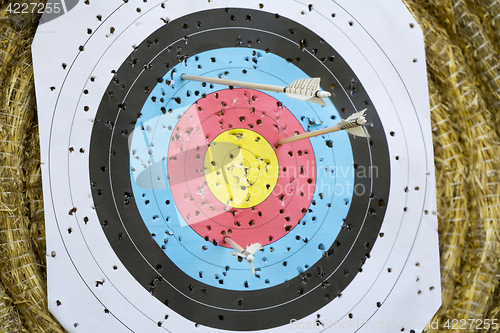 Image of Archery Target With Arrows On a straw background