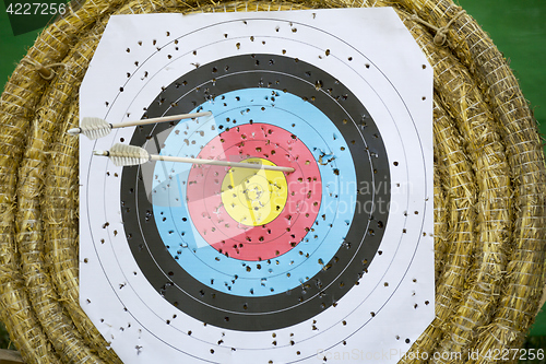 Image of Archery Target With Arrows On a straw background