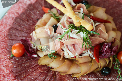 Image of Assorted meats and sausages, olives and spices, close-up.