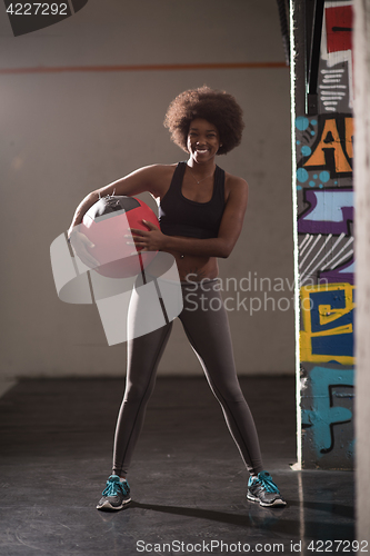 Image of black woman carrying crossfit ball