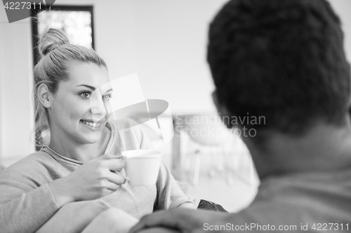 Image of Young multiethnic couple  in front of fireplace