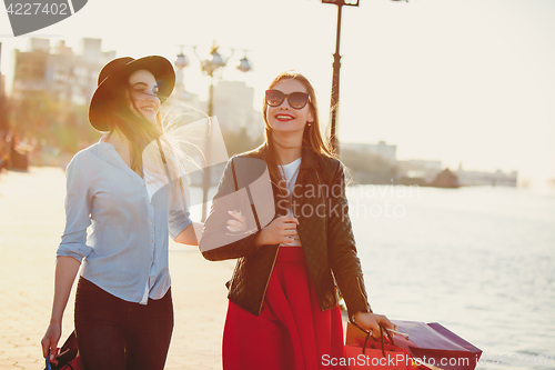 Image of Two girls walking with shopping on city streets