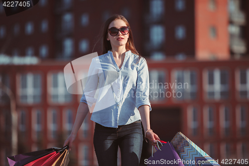 Image of The girl walking with shopping on city streets