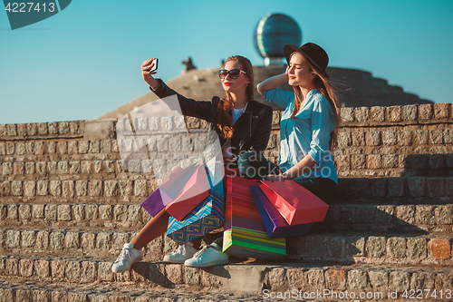 Image of Two girls walking with shopping on city streets