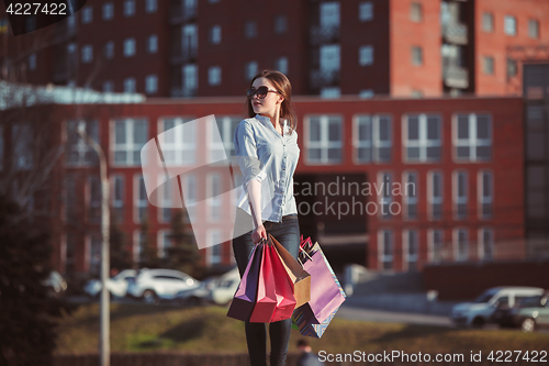 Image of The girl walking with shopping on city streets