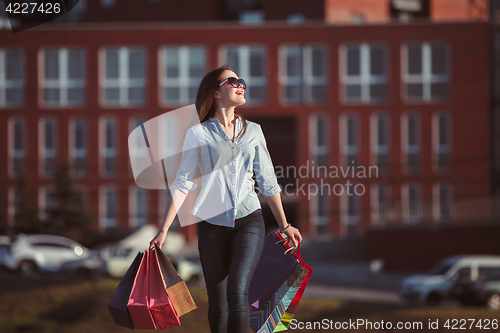 Image of The girl walking with shopping on city streets