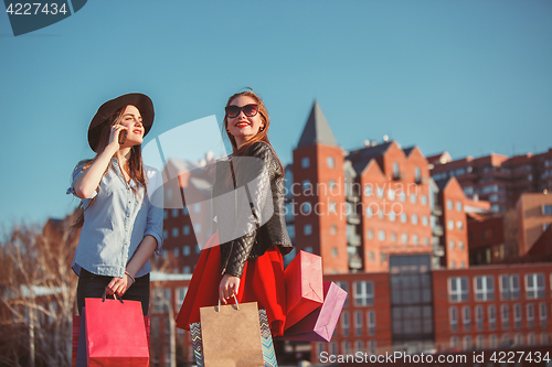 Image of Two girls walking with shopping on city streets