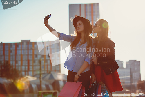 Image of Two girls walking with shopping on city streets