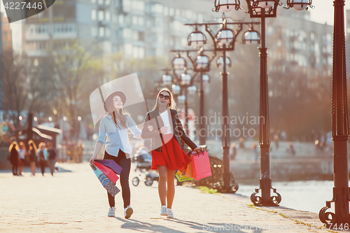 Image of Two girls walking with shopping on city streets