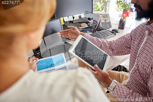 Image of business team with laptop, chart and tablet pc