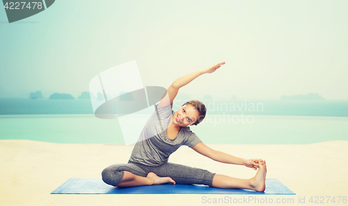 Image of happy woman making yoga and stretching on mat