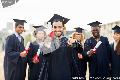Image of happy student with diploma pointing finger at you